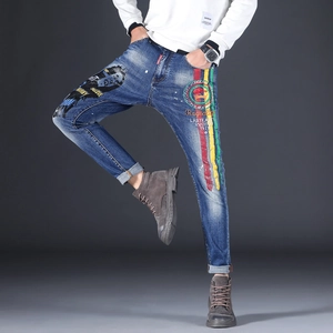 Detailed view of dark blue jeans with vintage wash, portrait print and stripe details