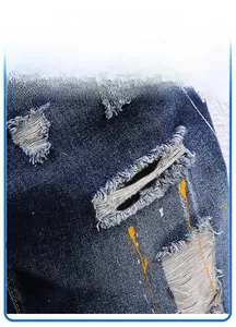Detailaufnahme der Jeans-Shorts im Distressed-Look mit gelben Farbspritzern und Rissen