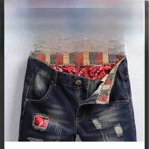 Detailed close-up of denim shorts featuring vintage patches and metal zipper fly