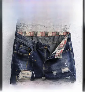 Detailansicht verwaschener Denim-Shorts mit Farbspritzern und Reißverschluss-Hosenschlitz