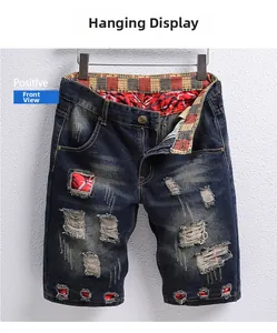 Detailed front view of men's distressed denim shorts with red plaid patchwork inserts