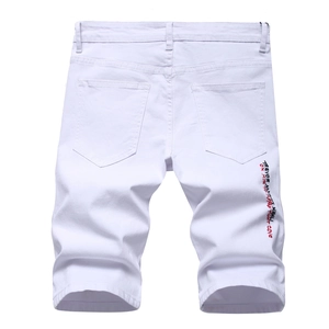 Detail view of white denim shorts with red and black TREVOR embroidery on the back leg