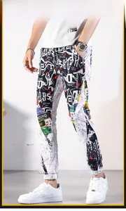 Detail von trendigen Herren-Jeans-Joggern in Slim Fit mit bunten Graffiti-Prints und Streifen