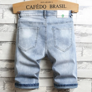 Short en jean bleu clair pour homme avec broderies et ourlet roulé sur un cintre