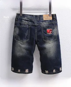 Rear view of distressed denim shorts with ripped patches and leather waist label