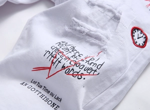 Detailed embroidery of heart clock and ripped denim texture on white shorts