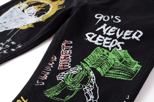 Detail of 3D skull and dollar graffiti print on black street style men's trousers