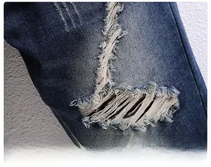 Detailed close-up showing distressed ripped denim fabric and vintage wash textures