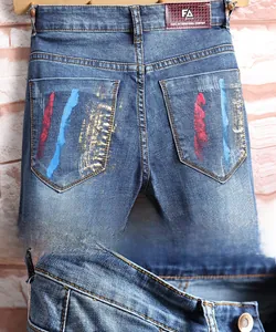 Détails du short en jean avec rayures peintes à la main et empiècement en cuir marron