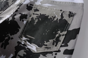 Close-up of white camo print denim showing pocket stitching and cotton twill texture
