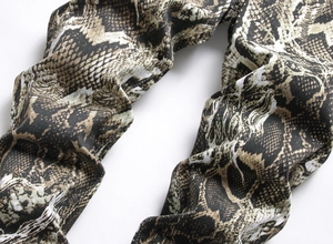 Close-up detail of realistic snakeskin pattern on slim fit denim pants for men
