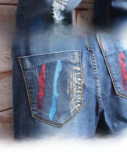 Détail de graffitis rouges et bleus sur la poche arrière d'un short en jean usé