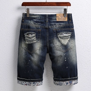 Mens distressed dark blue denim shorts with paisley lining and leather patch back view