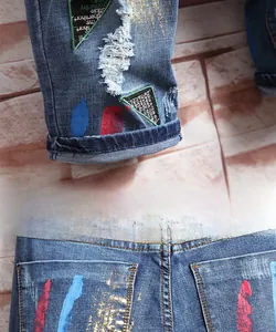 Vue détaillée du short en jean bleu avec taches de peinture et style troué à la mode