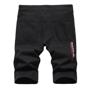 Detail of English letter embroidery on the back pocket of men's black denim shorts
