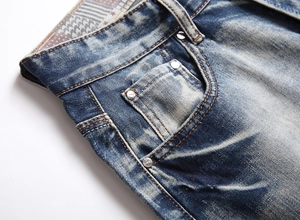 Detail view of vintage blue denim shorts showing coin pocket and washed cat-whisker effect
