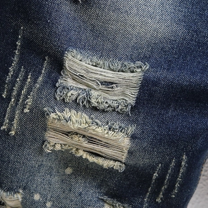 Deep blue distressed denim shorts with heavy washing and stylish ripped hole details