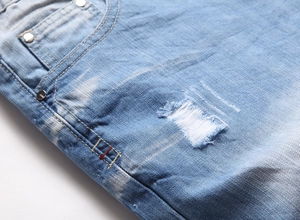 Détails du short en jean bleu clair avec déchirures usées et rivets métalliques