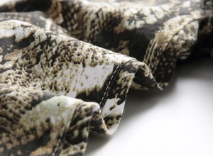 Macro shot of realistic snake print fabric with double-needle stitching on slim jeans