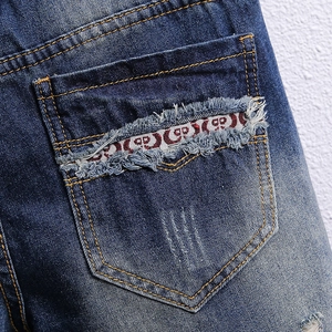 Men's vintage washed denim shorts with distressed back pocket detail and woven tape