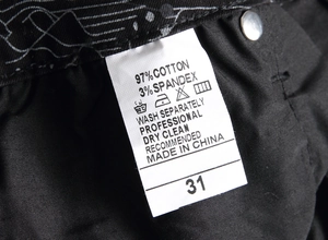 Detail of size label and fabric composition on black slim-fit graffiti jeans