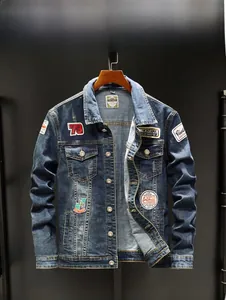 Detailed close-up of retro washed blue denim jacket featuring vintage patch embroidery and metallic buttons