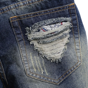 Men's deep blue distressed denim shorts with red paisley patch pocket detail