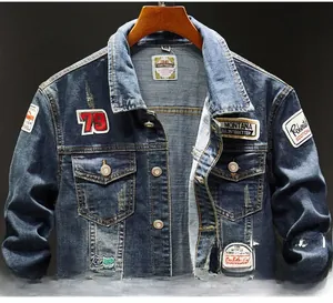 Detailed close-up of dark blue denim jacket featuring vintage patches and metal buttons