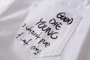 Close-up of white denim pocket with black 'GOOD DIE YOUNG' graffiti art print