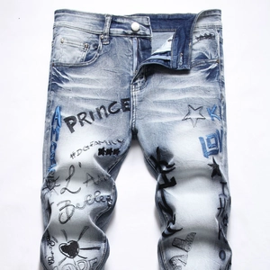 Detail of light blue slim jeans with street graffiti embroidery and washed texture
