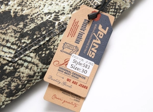 Detail of slim fit hip hop jeans showing snakeskin pattern, stitching, and size tag