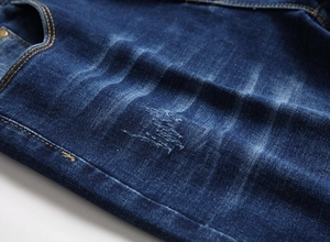 Detail der schmal geschnittenen blauen Jeans mit Taschen, Nähten und Denim-Textur