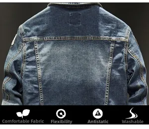 Macro detail of dark blue denim jacket showing embroidery badge and vintage wash texture