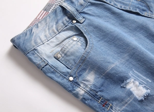 Détail d'un short en jean bleu délavé montrant les poches avant et les rivets métalliques