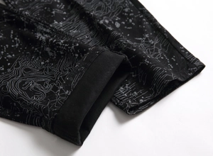 Close-up of black denim hem featuring white topographic map print and neat stitching