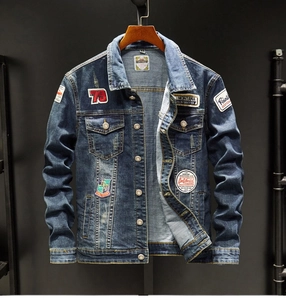 Detail of embroidered badges and distressed wash effect on dark blue denim jacket
