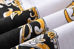 Vista macro del tessuto elasticizzato con stampa barocca nera, bianca e oro