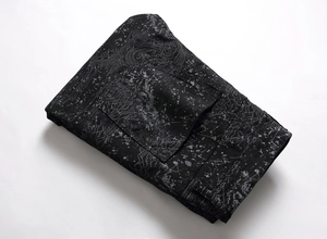 Detail of black jeans featuring unique grey contour lines and artistic splatter patterns