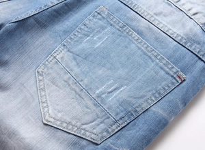 Détail d'un short en jean bleu clair avec poche arrière et coutures de renfort rouges
