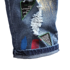 Short en jean pour homme avec déchirures, éclaboussures de peinture et patchs verts