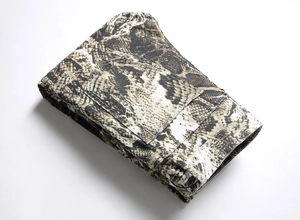 Detailed close-up of snakeskin print denim fabric featuring back pocket and stitching