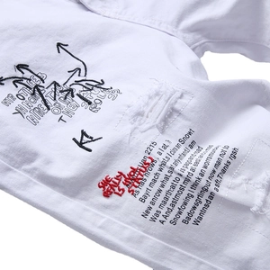 Slim fit white denim shorts for men featuring distressed holes and heavy embroidery design