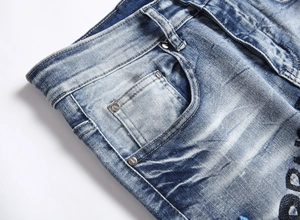 Close-up of hip hop jeans with vintage wash, pocket details and heavy embroidery