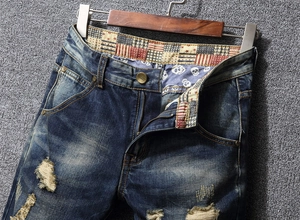 Close-up of distressed denim jeans with vintage wash and custom printed lining