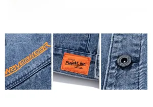 Detail of blue denim jacket showing orange letter embroidery and branded metal button