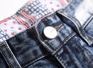 Macro shot of denim jeans waist with silver button and vintage star-patterned lining