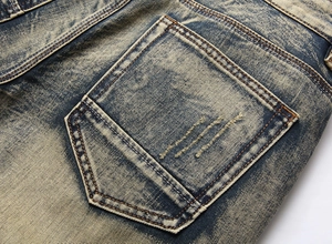 Close-up of vintage blue denim shorts showing heavy acid wash texture and back pocket stitching