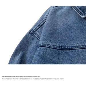 Detail view of denim jacket shoulder with double-stitched seams and panel construction