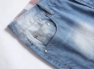 Détail du short en jean délavé bleu clair avec rivets métalliques et doublure à carreaux