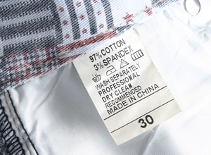 Close-up of summer denim shorts laundry tag showing 97% cotton material and size 30